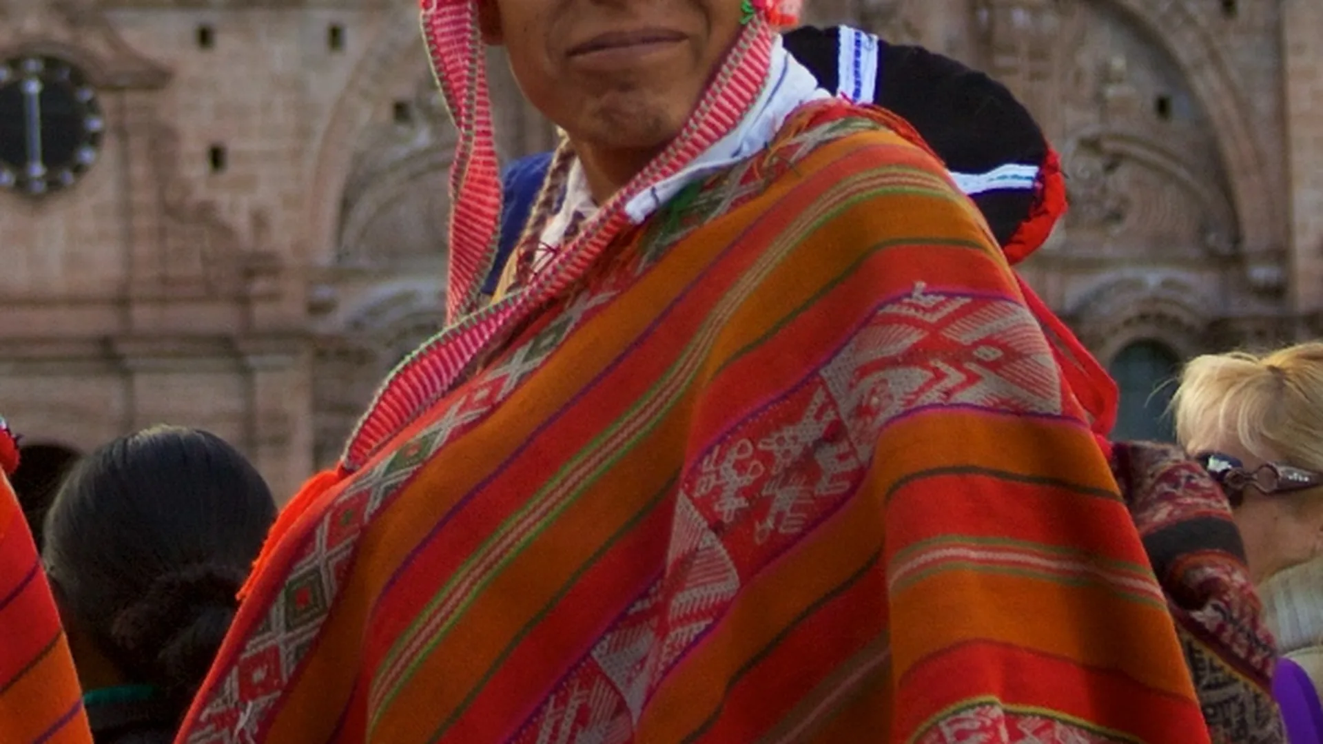 Peruvian folk dancers in colourful traditional Andean costume performing with panpipes and drums
